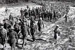 Captured French soldiers from Điện Biên Phủ, escorted by Vietnamese troops, walk to a prisoner-of-war camp