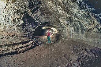 Valentine Cave in Lava Beds National Monument, California. This shows the classic tube shape; the grooves on the wall mark former flow levels. Pits near volcanic regions of Mars may be openings to caves like this.