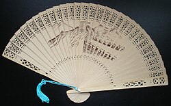 A commercially produced scented wood folding fan, featuring a drawing of the Great Wall of China.