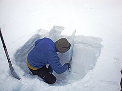 After digging a snow pit, it is possible to evaluate the snowpack for unstable layers. In this picture, snow from a weak layer has been easily scraped away by hand, leaving a horizontal line in the wall of the pit.