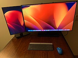 Vertical monitor in portrait orientation to the left and a landscape main display in the center