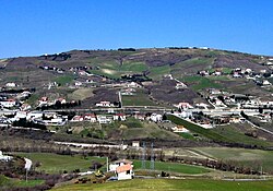 The Costa della Gaveta earthflow in Potenza, Italy. Even though it moves at a rate of just a few millimeters per year[15] and is hardly visible, this landslide causes progressive damage to the national road, the national highway, a flyover, and several houses that are built on it.