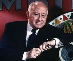 Closeup of DeMille leaning on a setpiece