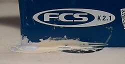 Special epoxy is strong enough to withstand the forces between a surfboard fin and the fin mount. This epoxy is waterproof and capable of curing underwater. The blue-colored epoxy on the left is still undergoing curing