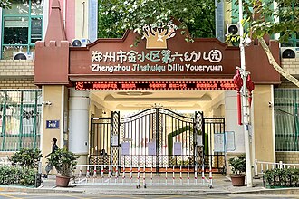 A facade of a kindergarten in Zhengzhou, Henan, with writing using simplified characters and pinyin