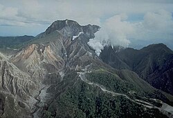 Pinatubo as viewed from the north in late April 1991. Grayish-tan ash and several craters from the April 2 phreatic explosions are visible at the left.