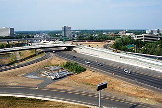 I-495 Express Lanes (HOT lanes) under construction at the I-495 interchange with SR 123 in Tysons. At the left is the elevated ramp to access the HOT lanes from SR 123 via Westpark Drive (Tysons Corner). In the background is the Silver Line viaduct.