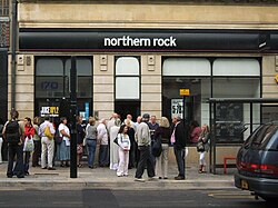 A number of people queuing at the door of a branch of the Northern Rock bank.