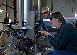 NIST physicists Steve Jefferts (foreground) and Tom Heavner with the NIST-F2 caesium fountain atomic clock, a civilian time standard for the United States
