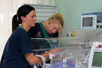 Two trainee nurses operating a neonatal incubator in 2011