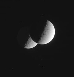 A grazing occultation of Rhea by Dione, two moons of Saturn, imaged by Cassini–Huygens.