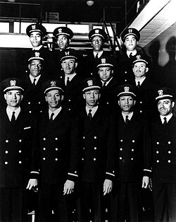 The Golden Thirteen, photographed on 17 March 1944. The navy class consisted of 16 African American men who were selected for navy training.[198] Initially passing the training courses with outstanding scores, the group faced overt discrimination from by the US Navy and were forced to resit their exams due to pervasive racism.[198][199][200]