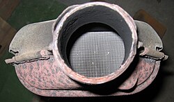 Solid heterogeneous catalysts are plated on meshes in ceramic catalytic converters in order to maximize their surface area. This exhaust converter is from a Peugeot 106 S2 1100