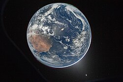 Hello, World photograph taken by Wiseman from Integrity after trans-lunar injection, showing the full Earth with its night side illuminated by the Moon. The mission included the first human-taken photos of the full Earth disk since the Apollo program.