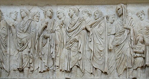 Three flamines in their distinctive pointed headgear, grouped to the centre of a panel from the Ara Pacis