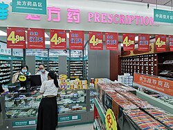 A large pharmacy in China, with western prepackaged medicines at the left, and various herbal medicines in cabinets at the right