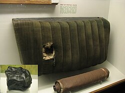 Car seat and muffler hit by the Benld meteorite in 1938, with the meteorite inset. An observed fall.