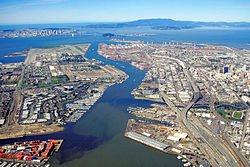The runways and remainder of the Alameda Naval Air Station can be seen at the end of Alameda Island in this aerial view of the port of Oakland, California.