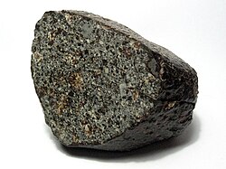 This small meteorite is from the NWA 869 strewn field, near Tindouf, Algeria. Currently classified as an L3.8-6 ordinary chondrite it shows brecciation and abundant chondrules.[78]