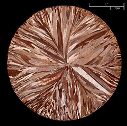 A copper disc (99.95% pure) made by continuous casting; etched to reveal crystallites