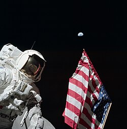 Harrison Schmitt poses by the American flag deployed on Apollo 17, December 11, 1972.