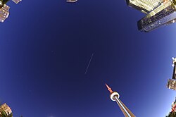 The ISS visible as a skytrack line drawn in the sky nearly overhead shortly after sunset by a long exposure photo