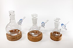 Three Schlenk flasks with 500, 250 and 100 mL volume on cork rings.