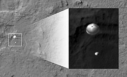 The Curiosity rover during atmospheric entry as seen by HiRISE on August 6, 2012. Supersonic parachute and backshell visible