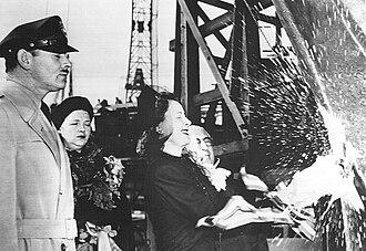 Dunne christens SS Carole Lombard next to Louis B. Mayer. Standing behind her is Clark Gable, Carole Lombard's widower, and Lombard's secretary Madalynne Field.