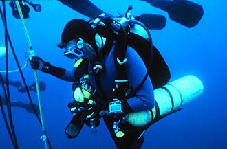 Technical diver wearing a dive computer on his left wrist during a decompression stop.