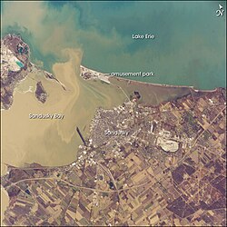 Muddy brown water fills Sandusky Bay, just south of Lake Erie in this astronaut photograph.
