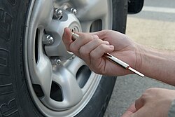 Checking tire pressure with a spring and piston tire-pressure gauge
