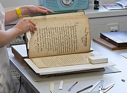 A paper conservator handling a book
