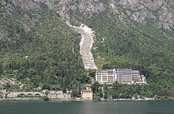 Hotel Panorama at Lake Garda. Part of a hill of Devonian shale was removed to make the road, forming a dip-slope. The upper block detached along a bedding plane and is sliding down the hill, forming a jumbled pile of rock at the toe of the slide.