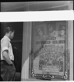 Passerby views original movie poster for The Fighting 69th in 1940