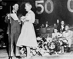 Ohio Governor C. William O'Neill served as master of ceremonies for Ruth Lyons Day in 1957. He and Lyons are seen at left. Lyons's daughter, Candy, program co-host, Bob Braun and husband, Herman Newman, are seen at right. Lyons is holding her trademark bouquet of flowers which concealed her microphone.