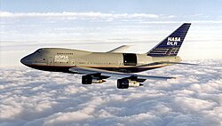 The SOFIA aircraft pictured during a test flight in 1998. Still mostly in United Airlines livery, a black square has been painted on the aft fuselage to indicate the location of the door that would be opened in flight to allow the telescope access to the sky.