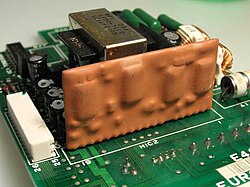 An epoxy encapsulated hybrid circuit on a printed circuit board.