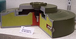 Section of an anti-tank mine. Note the yellow main charge wrapped around a red booster charge, and the secondary fuze well on the side of the mine designed for an anti-handling device.