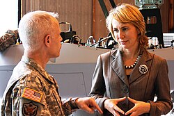 Representative Giffords speaking with a military officer in July 2010