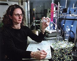 A researcher at Sandia National Laboratories examines vials of SOMS (Sandia Octahedral Molecular Sieve), a zeolite that shows potential for radioactive waste and industrial metals cleanup.