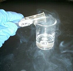 Fumes from hydrochloric acid and ammonia forming a white cloud of ammonium chloride