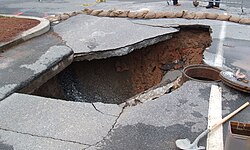 A 32-foot-deep (9.8-meter) collapse formed by rainwater leaking through pavement and carrying soil into a ruptured sewer pipe in the parking lot at Georgia Tech in Atlanta, Georgia in 2005