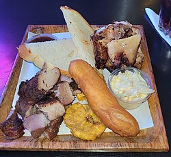 Jamaican jerk pork and chicken with festival, hard dough bread and tostone.