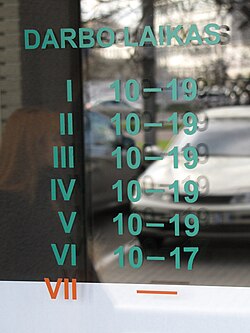 Business hours table on a shop window in Vilnius, Lithuania.