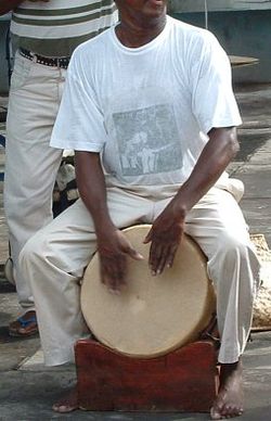 Maloya player using a traditional rouler (a wooden drum with goatskin)