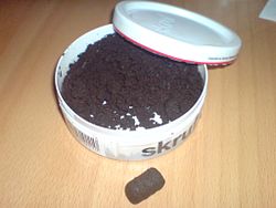 A can (or tin) of Skruf brand loose (Swedish: lös) snus, with some formed into a pris or prilla