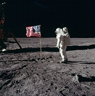 Photo of the first national flag assembled by a human on the Moon (Apollo 11, 1969). With colonization of space having been a critically discussed issue since the dawn of the space age, resulting in the Outer Space Treaty (1967), the flag was not to symbolize any territorial claims.[1]