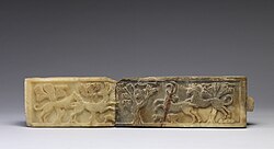 A South Arabian relief from the fifth century BC, in Walters Art Museum. On the left side of this relief, a lion attacks a gazelle, while a rabbit tries to jump away from the gazelle's forelegs. On the right, a leopard jumps down from rocks onto the back of an ibex; a small rodent flees the hoofs of the ibex. Birds in the branches of acacia trees observe the two scenes.