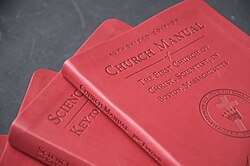 several red hard cover books in a pile